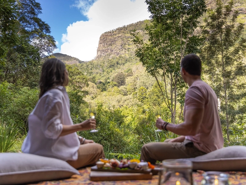 Couple enjoying a welcome platter with a glass of Australian sparkling on the front deck.