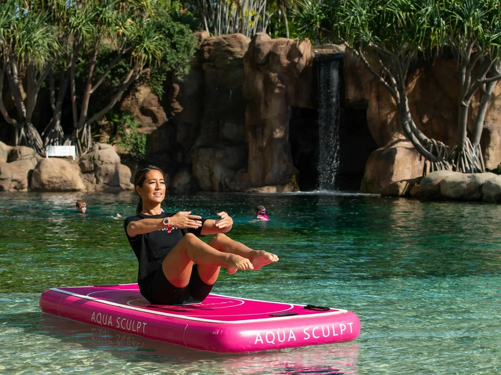 Participant in a yoga pose and balance challenge at a pool in Surfers Paradise