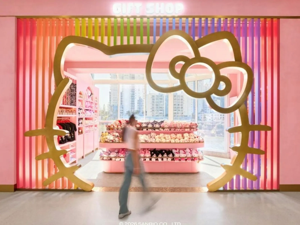 A retail entrance framed by a large Hello Kitty silhouette with pink interior.