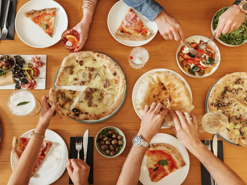 4 people sharing Fire Baby Pizza on the table