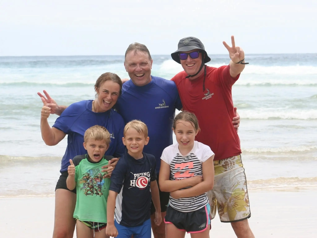 A family celebrates an unforgettable beach day after their surf adventure on the Gold Coast.