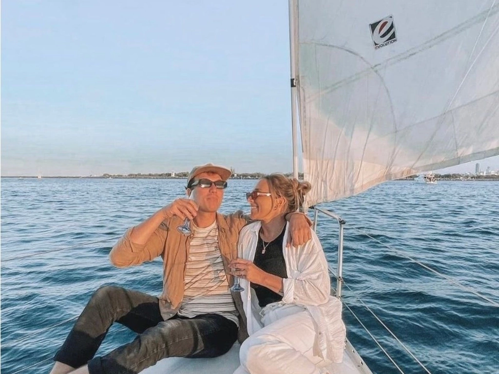 Romantic couple sailing aboard Sun Sailing's sunset private charter sipping sparkling wine.