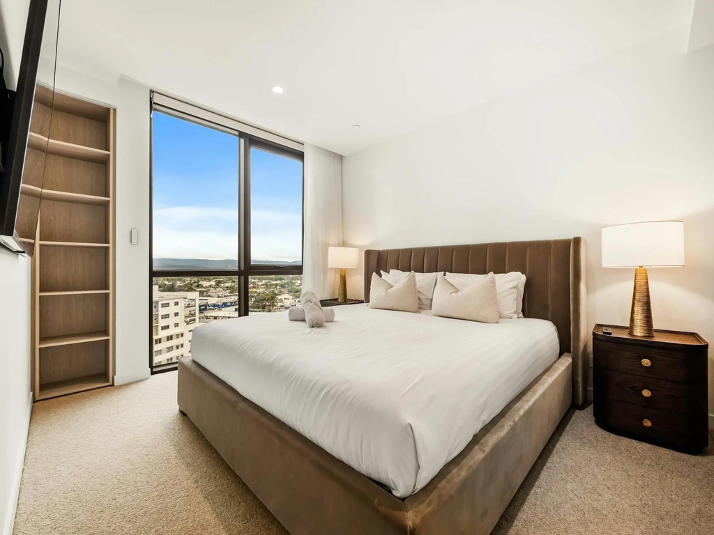 Second bedroom with a queen bed, built in shelving and a district outlook.