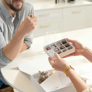 woman holding open a box of chocolates.