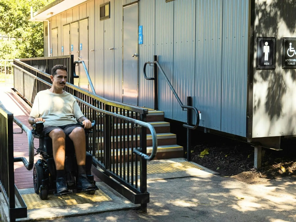 A visitor using the wheelchair ramp at an accessible toilet block at Lone Pine Koala Sanctuary.