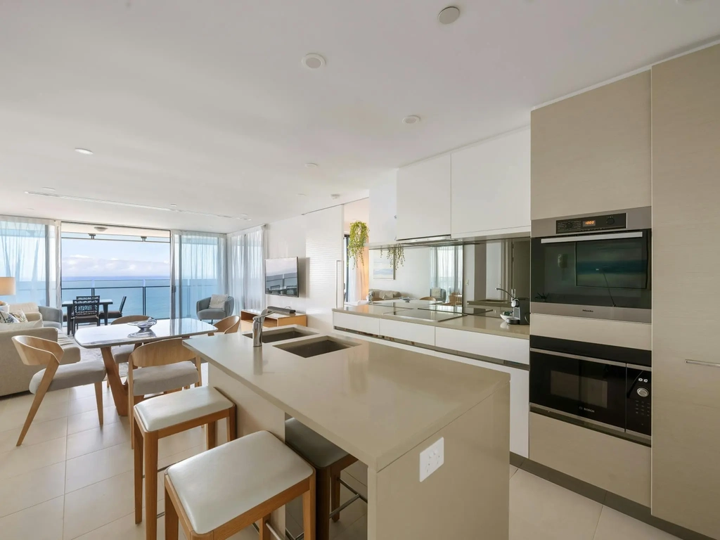 Kitchen with island bench, induction cooktop and wall oven in a Surfers Paradise apartment