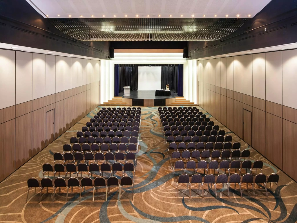 A function room with chairs arranged in rows, prepared for a seminar