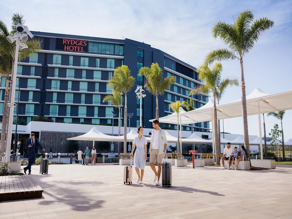 Passengers walking through International Arrivals Plaza from Rydges Hotel