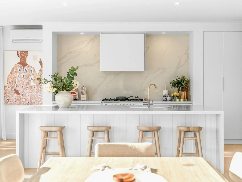Modern kitchen with a stone island bench and bar stools