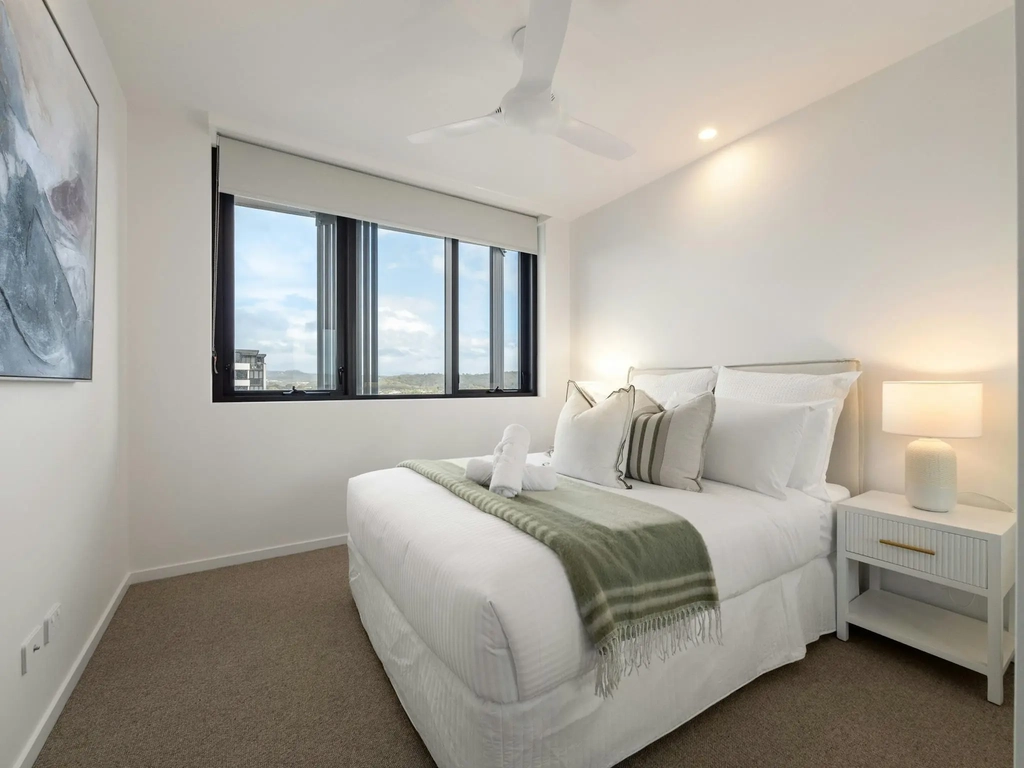 Second bedroom with king bed, ceiling fan and district outlook