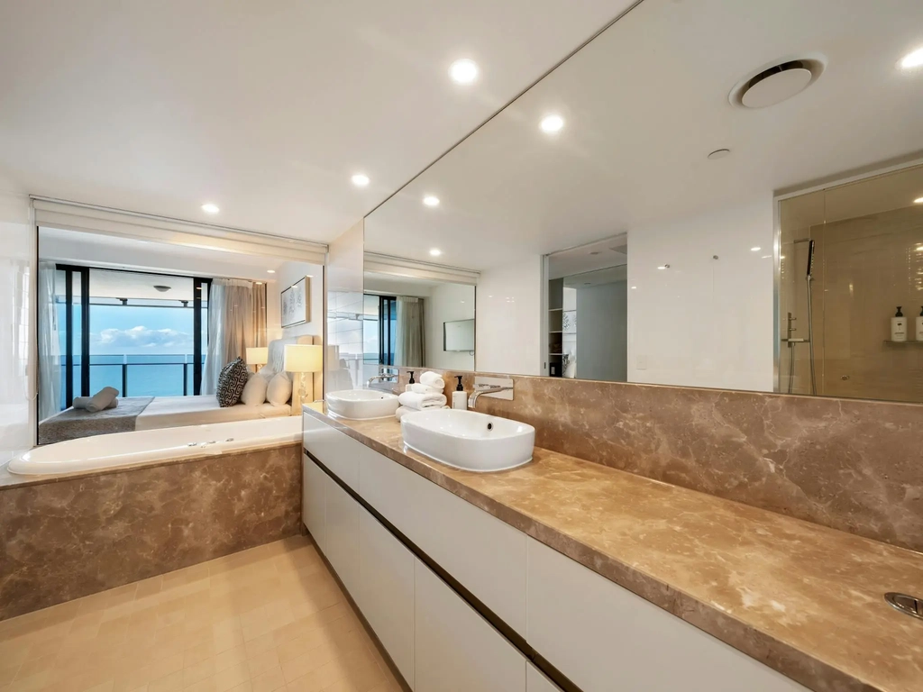 Ensuite bathroom with a spa bath and twin basins in an apartment