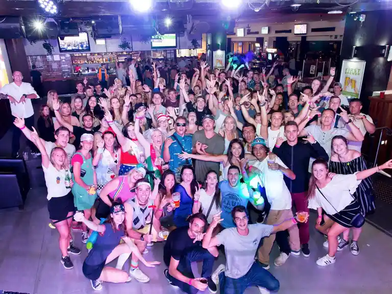 Whole group party tours posing for a photo, at the beginning of the club crawl