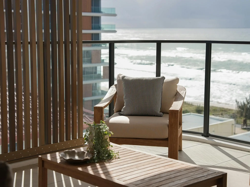 Terrace with timber screens and armchair looking over the beach and surf