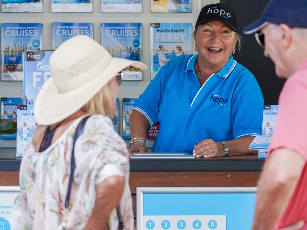 Woman in blue Hopo shirt laughs with a male and female customer