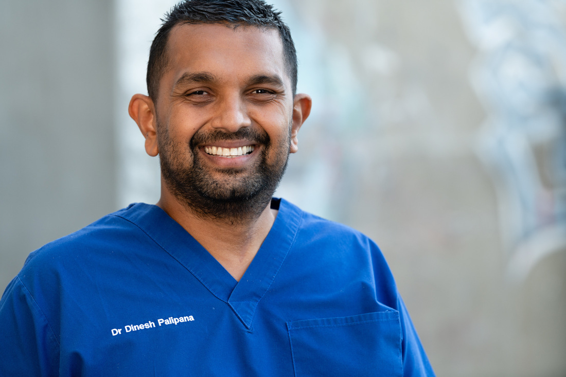 Dinesh Palipana in dark blue scrubs facing camera