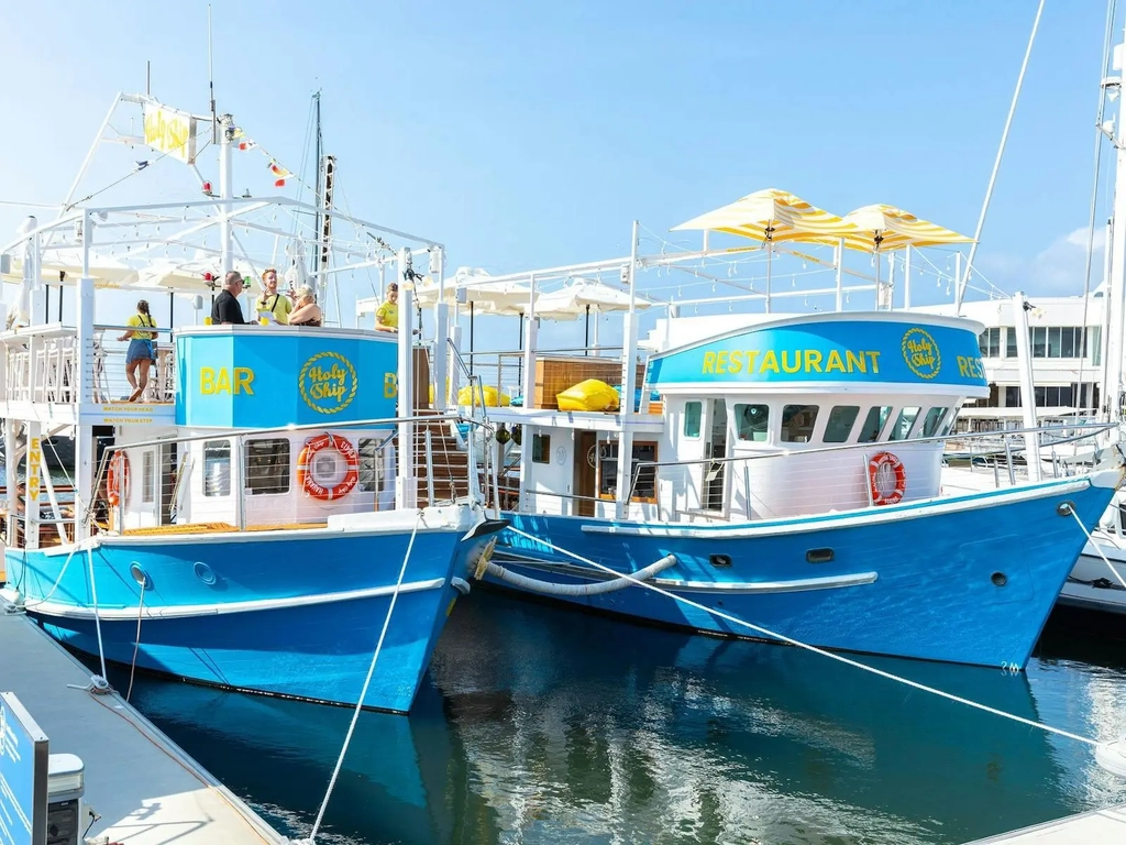 Two blue trawlers part of holy ship restaurant and bar docked at Marina Mirage
