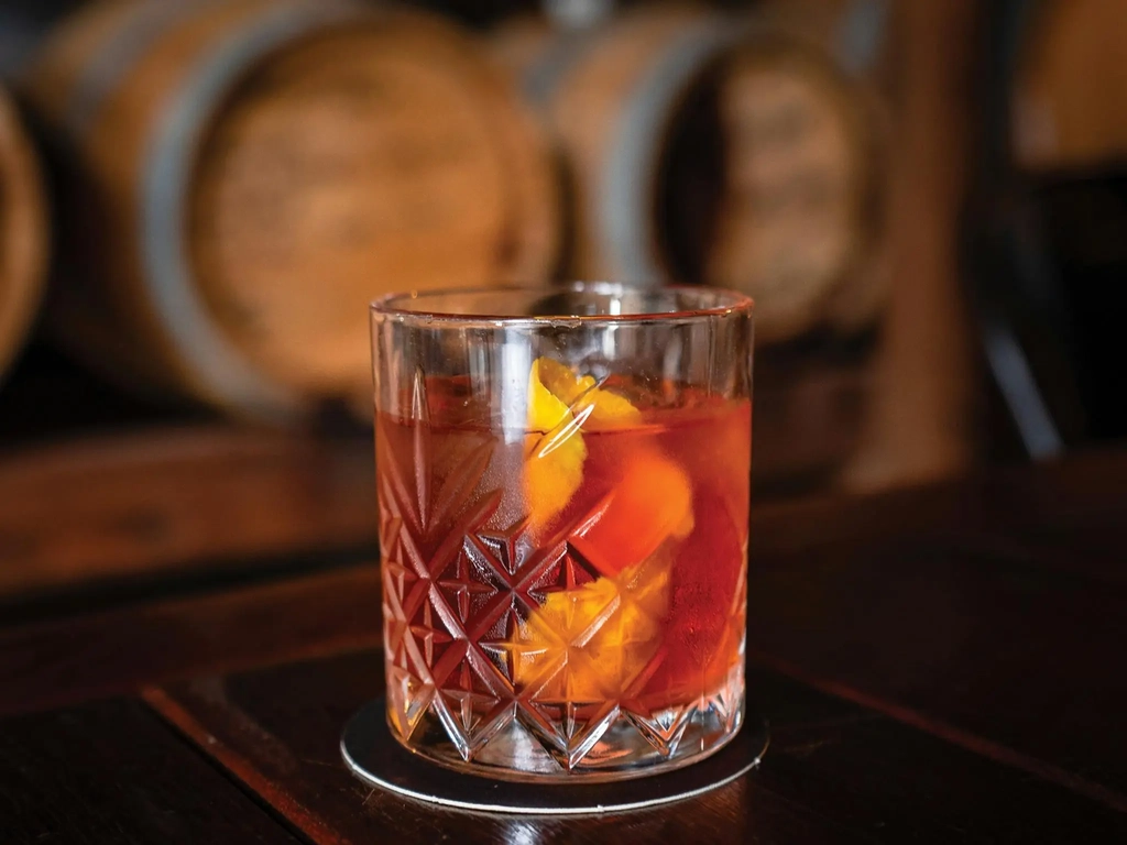 A negroni cocktail in front of the barrel room at Granddad Jack's Craft Distillery.