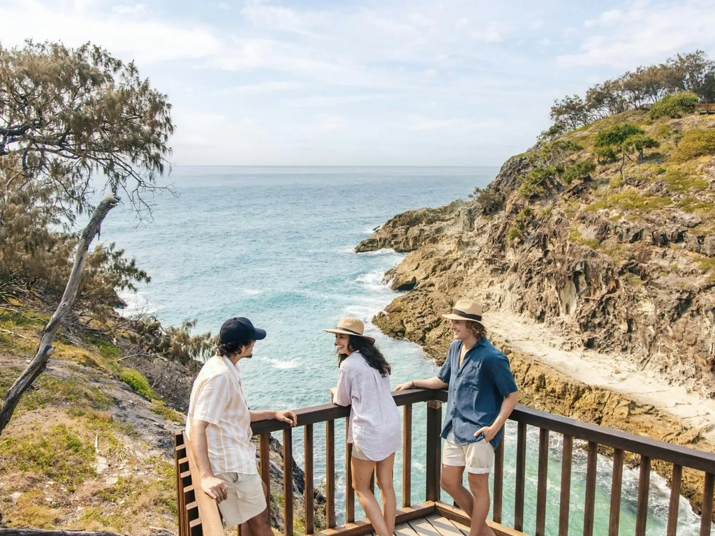 Tourists pausing at the top of the stairs leading down to the beach
