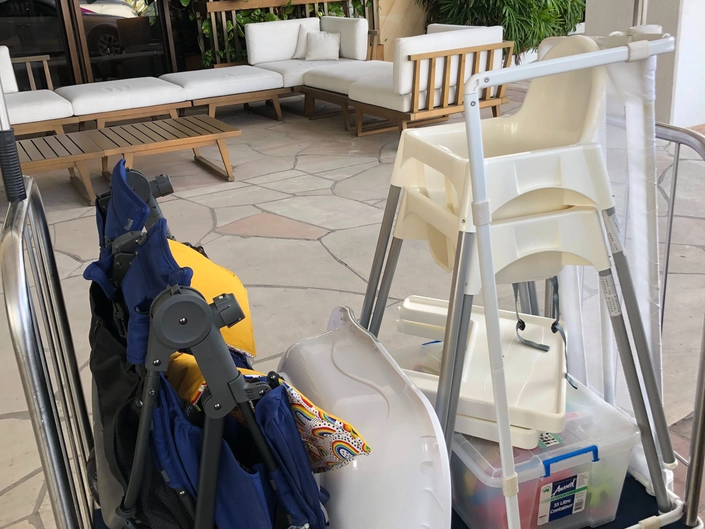 A pram, high chair and other baby gear on a luggage trolley at the  Marriott.