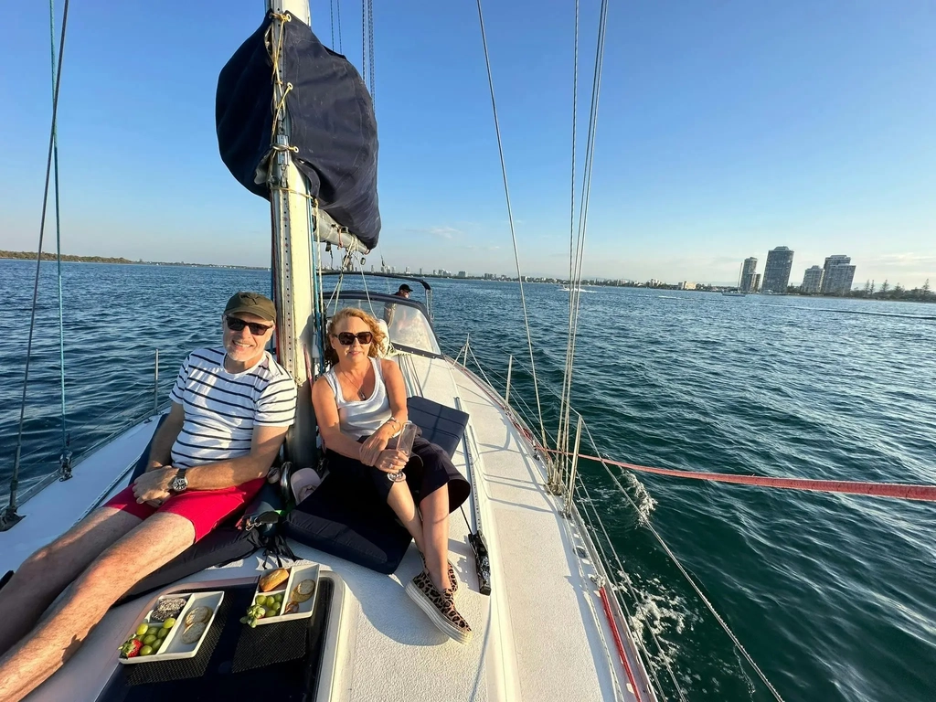 Couple sitting on deck of Epsilon, 38ft monohull yacht. Enjoying an afternoon sail.