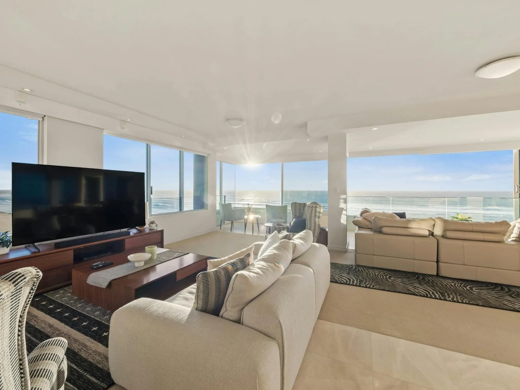 Beachfront apartment living room with full-height glass and ocean views at Main Beach