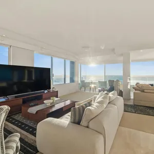 Beachfront apartment living room with full-height glass and ocean views at Main Beach
