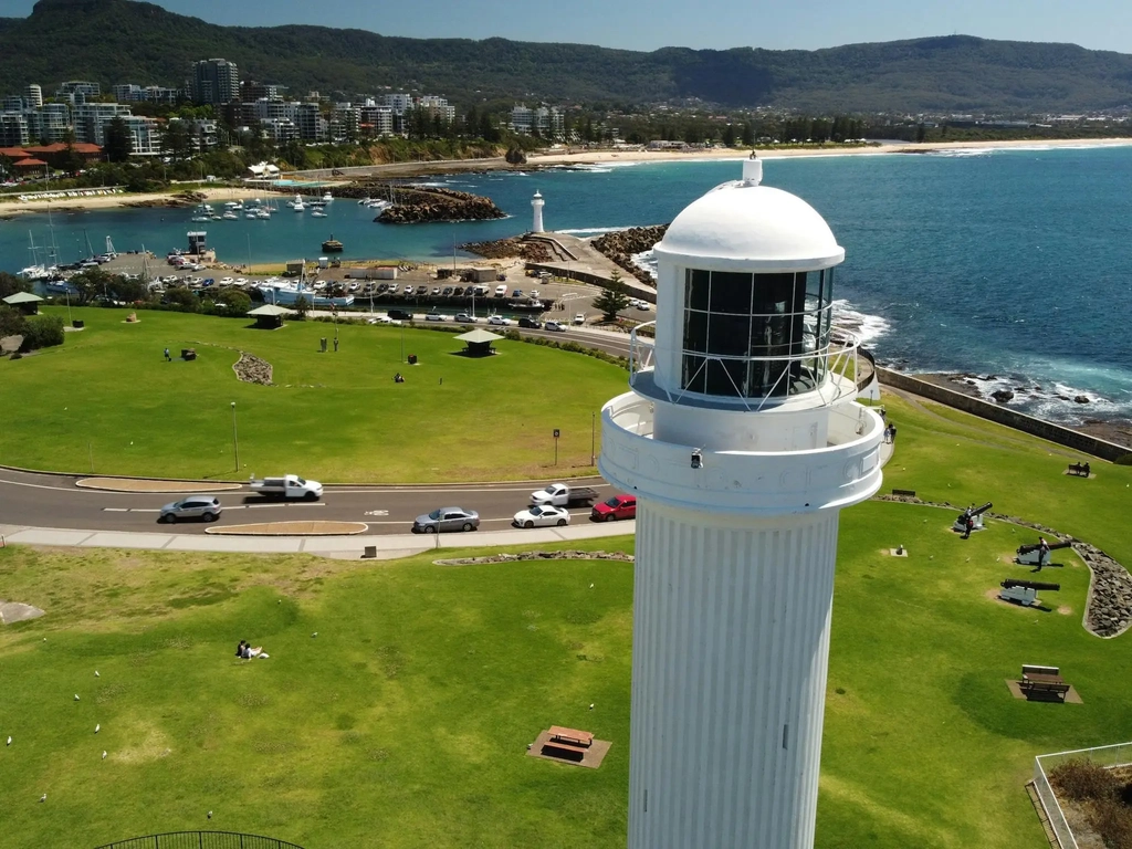A drone photo of Belmore Basin in Wollongong showing both lighthouses and the escarpment in the back