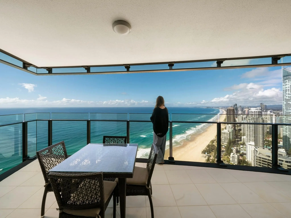 Outdoor dining setting on an apartment balcony overlooking the Gold Coast coastline