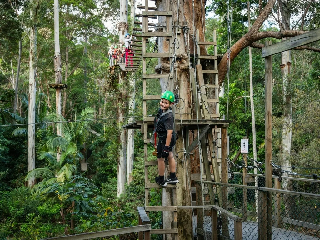 Kids 8 and older can climb on the course. Kid climbing down a ladder