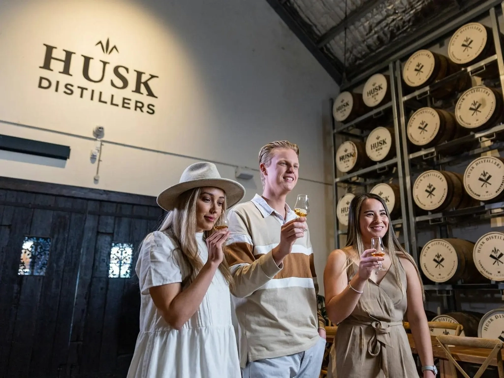 Guests tasting spirits in the barrel house at Husk Farm Distillery