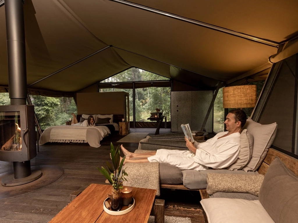 Guest couple relaxing inside safari tent accomodation.