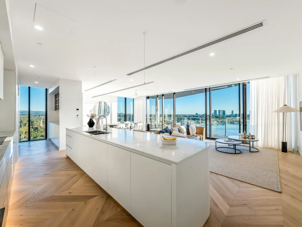 Open living and kitchen with herringbone oak floor and floor-to-ceiling river views