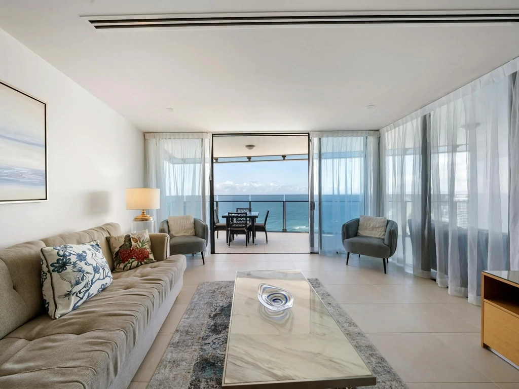 Living room opening onto a balcony with ocean views in a Surfers Paradise apartment