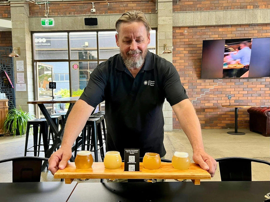 South East Discovery Tours host, PJ, placing a beer paddle on the table at Future Magic Brewing Co.