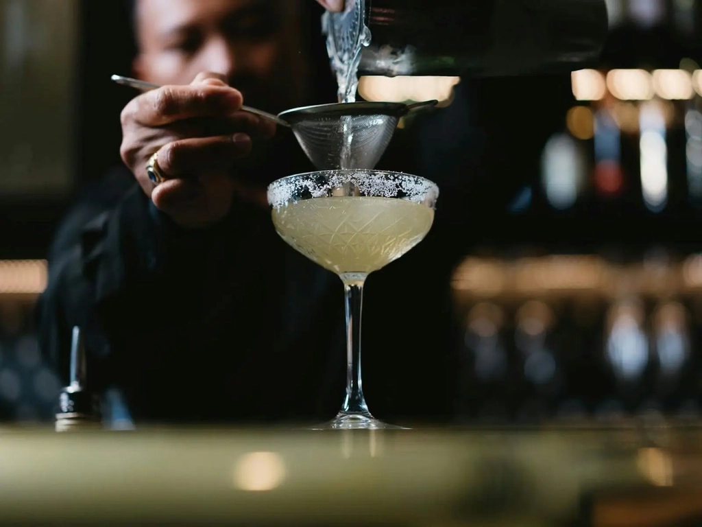 Bar tender pouring cocktail