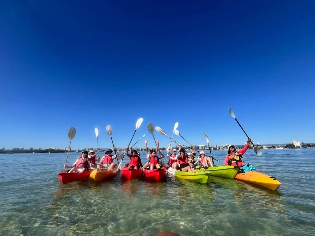Group of guests in colourful kayaks enjoying the shallow waters near Wave Break Island