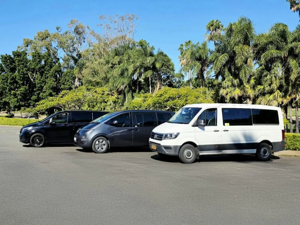 Mercedes, Hyundai, and Volkswagen vans from GEC Transfers parked in a row under a sunny sky