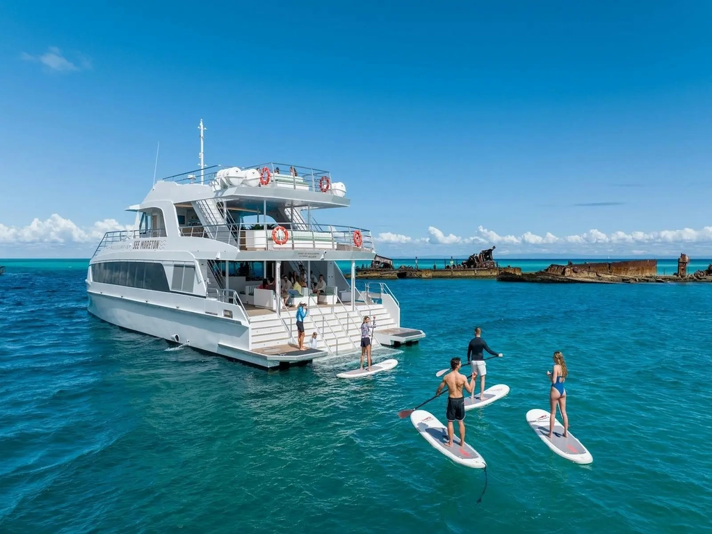 Stand up paddleboarders exploring the Tangalooma Wrecks