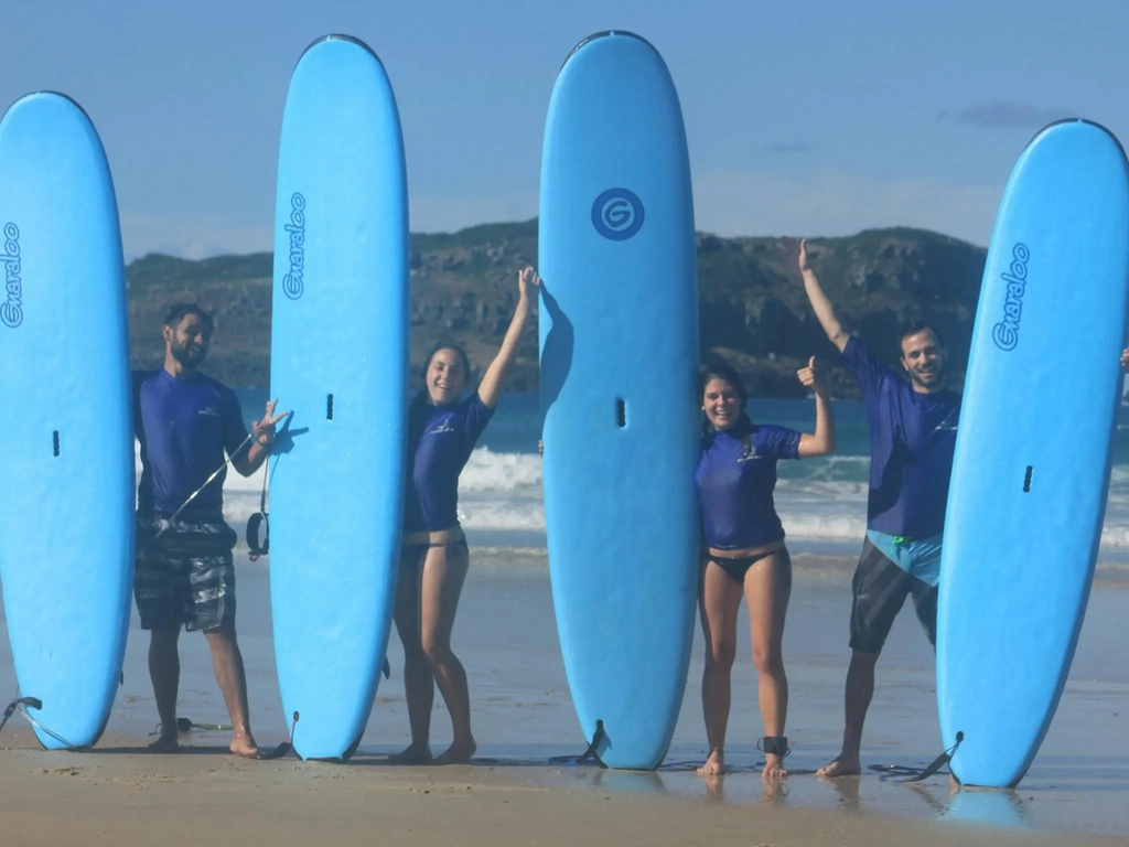 Surf crew lined up with their boards, all smiles!