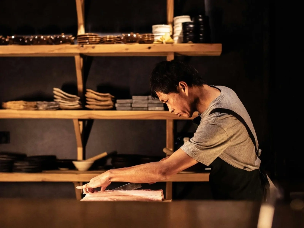 Japanese Chef Koki carving fish in his restaurant