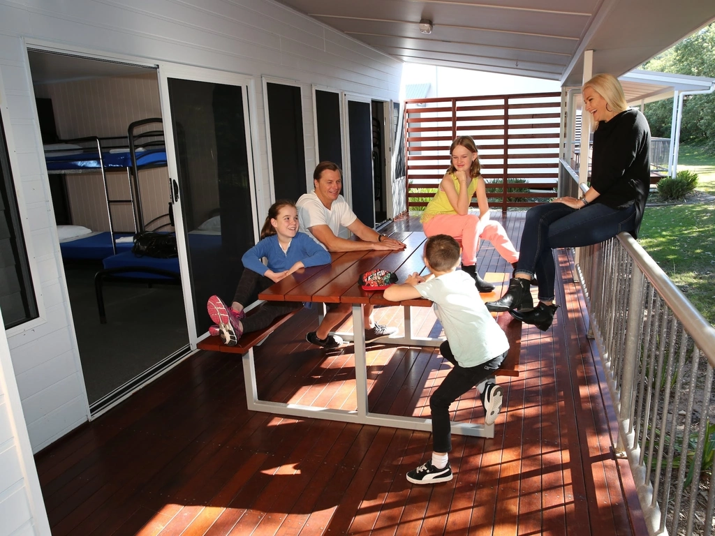 Family sitting on deck in dappled light