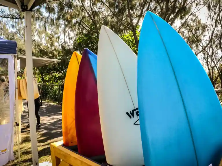 four brightly coloured surf boards on a hand made rack