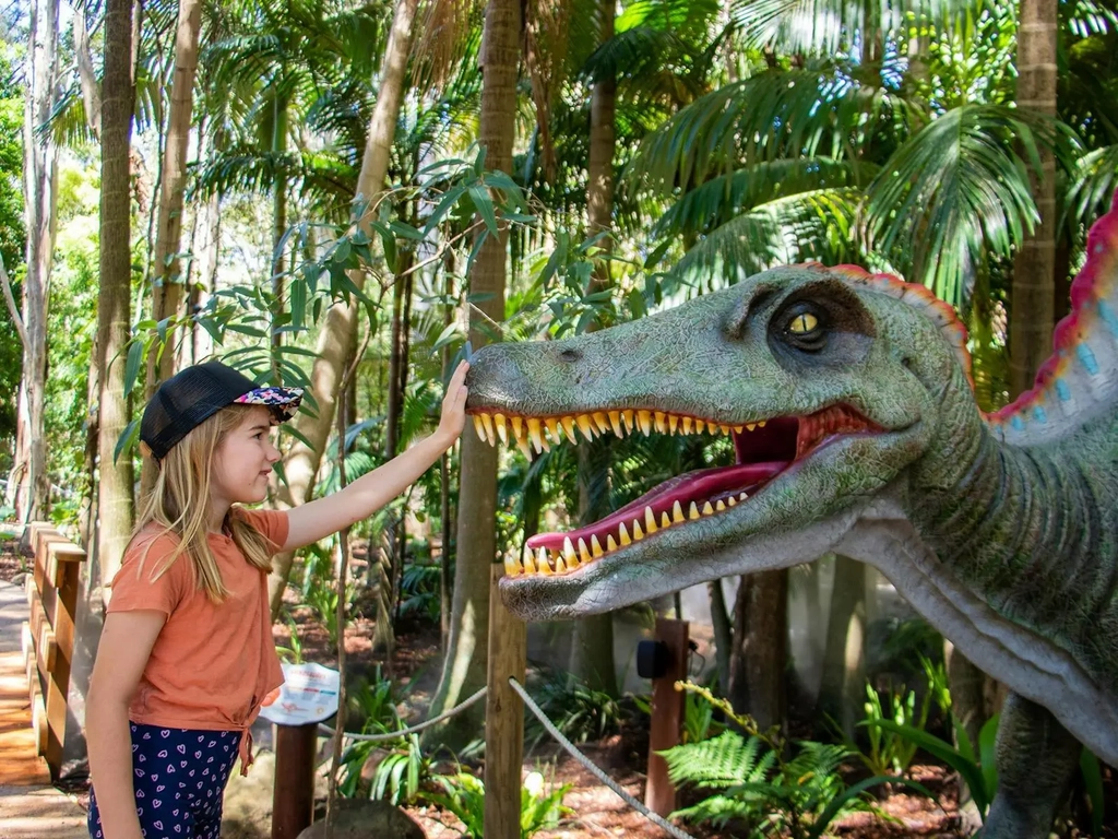 Young girl petting dinosaur at Currumbin Wildlife Sanctuary