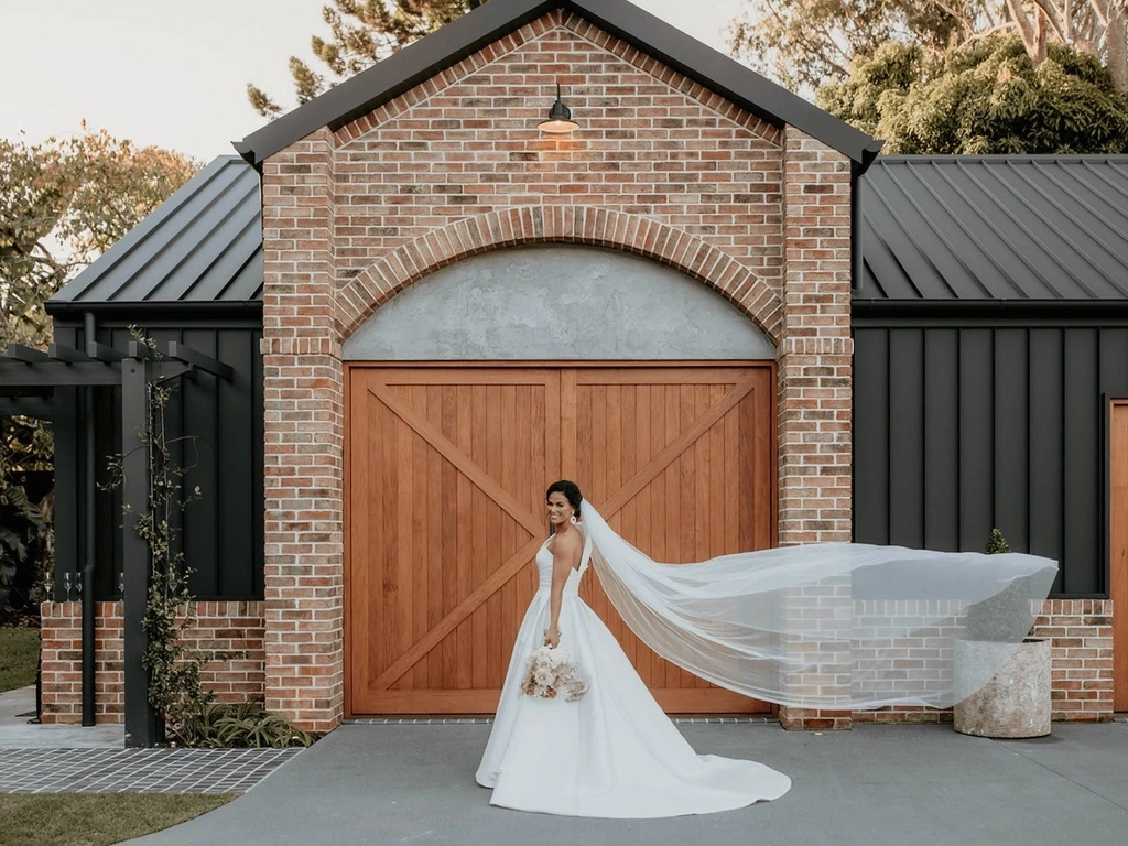 Bride standing in front of the Gentlemen's Retreat at The Valley Estate