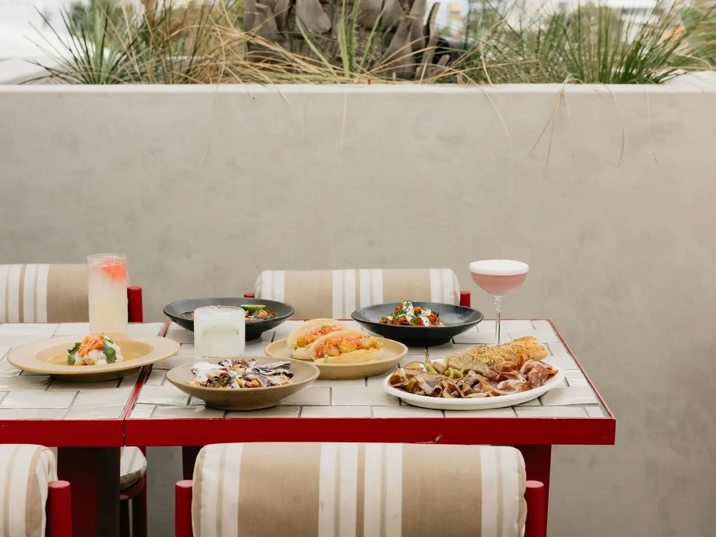 A full spread of food on red and white table