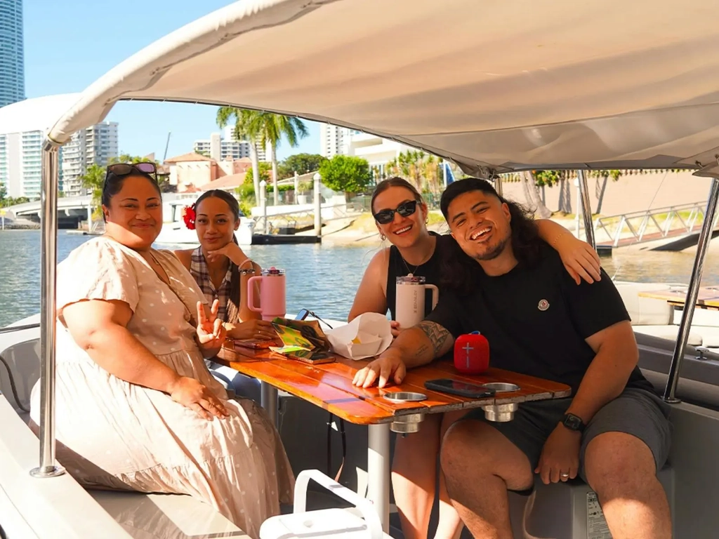 Friends sharing a picnic and drinks aboard a self-drive GoBoat on the Gold Coast.