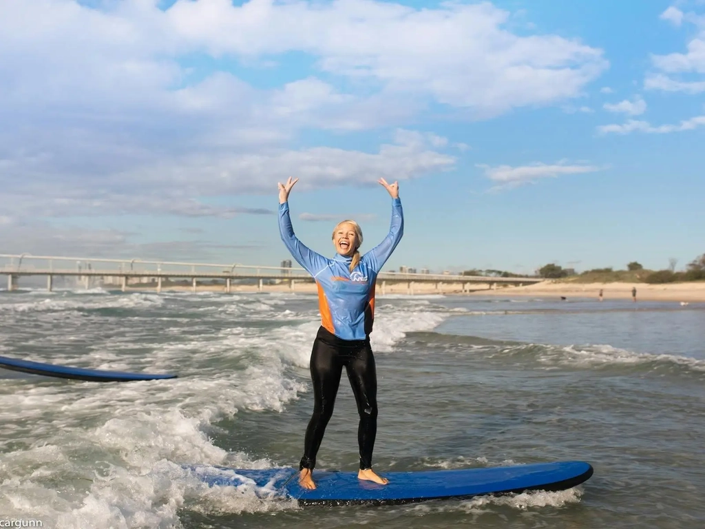 A stoked student standing up on her first wave!