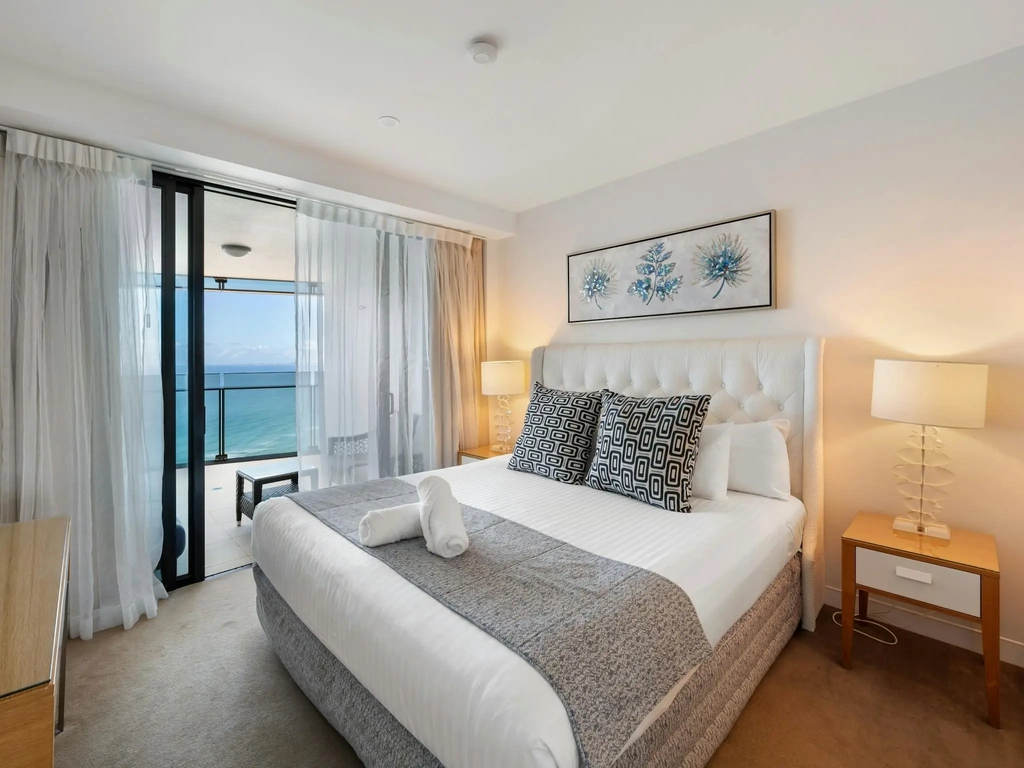 Main bedroom with a king bed and balcony access overlooking the ocean