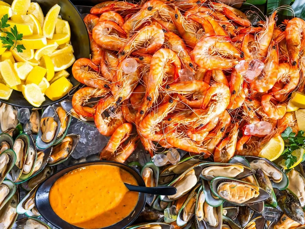 Ocean king prawns on a platter next to mussels and cocktail sauce