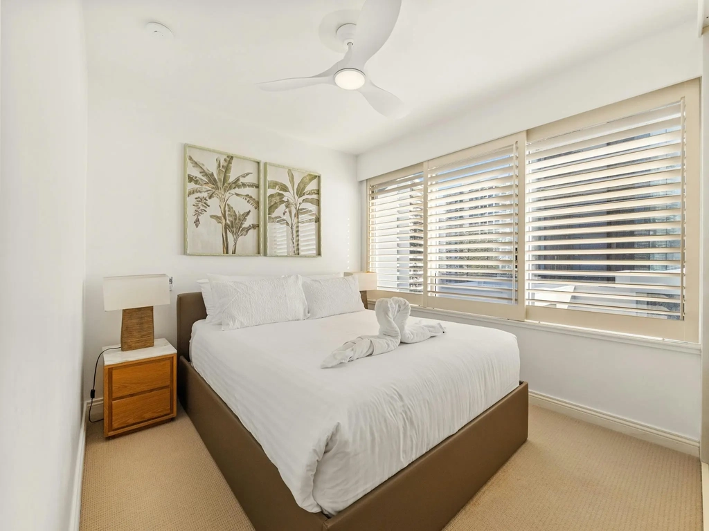 Second bedroom with queen bed and plantation shutters